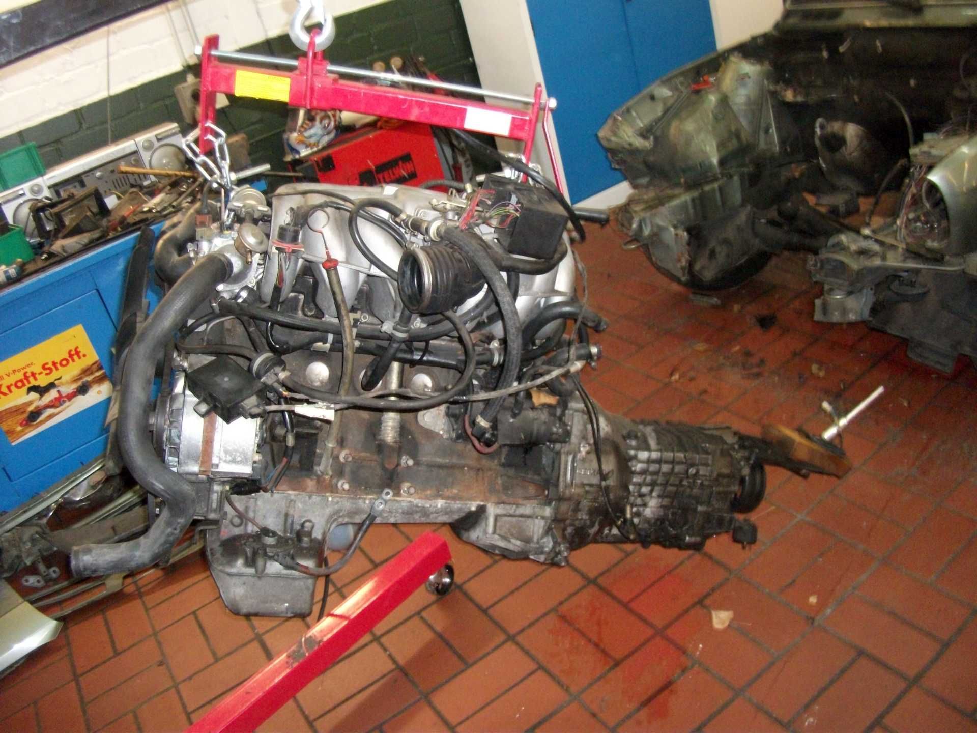 Ein Automotor wird von einem Kran in eine Garage gehoben