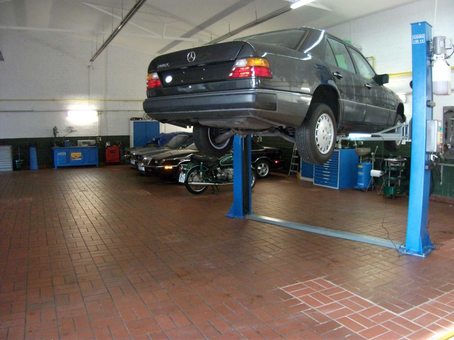 Ein Auto steht auf einer Hebebühne in einer Garage