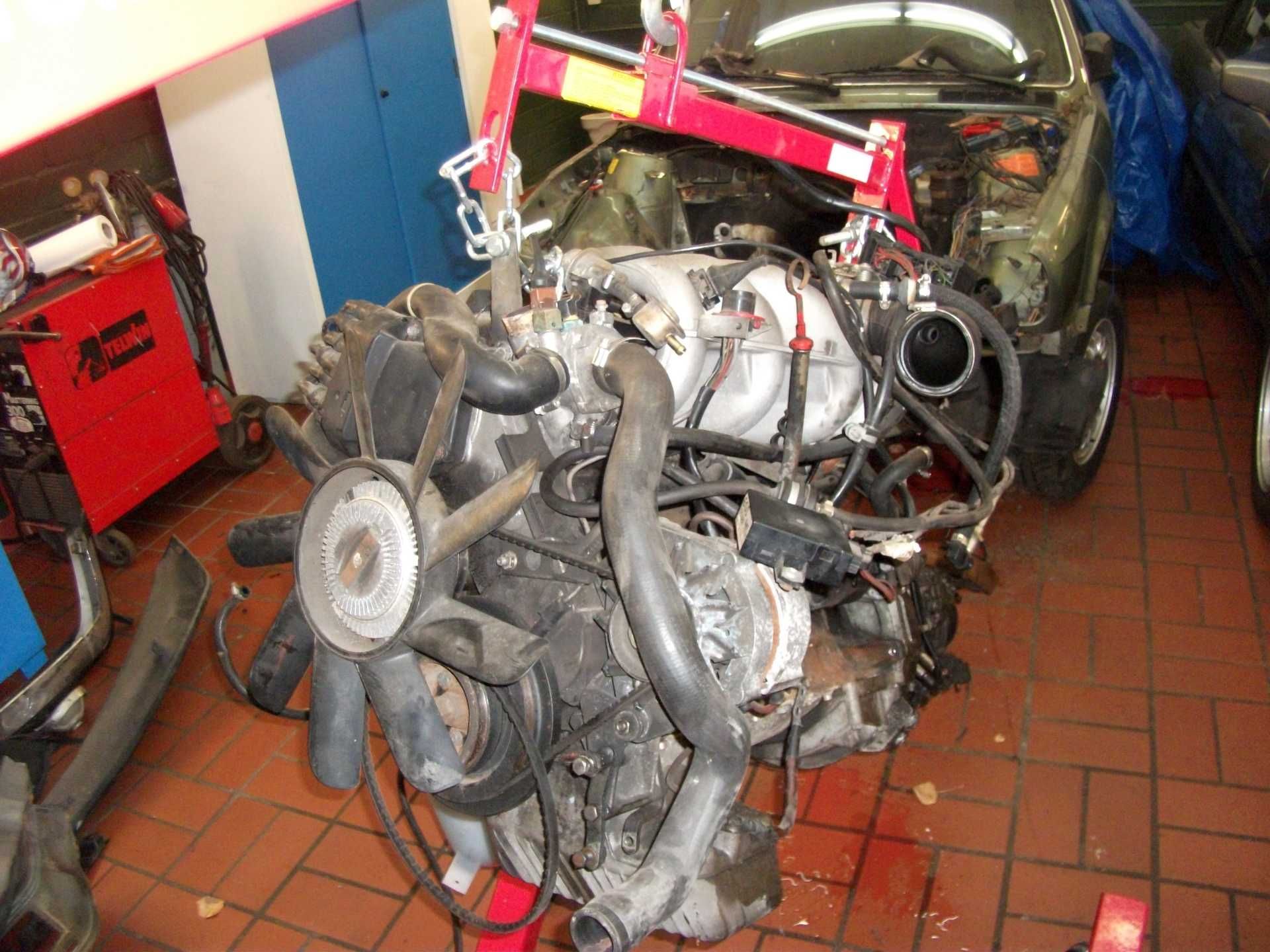 In einer Garage wird an einem Automotor gearbeitet