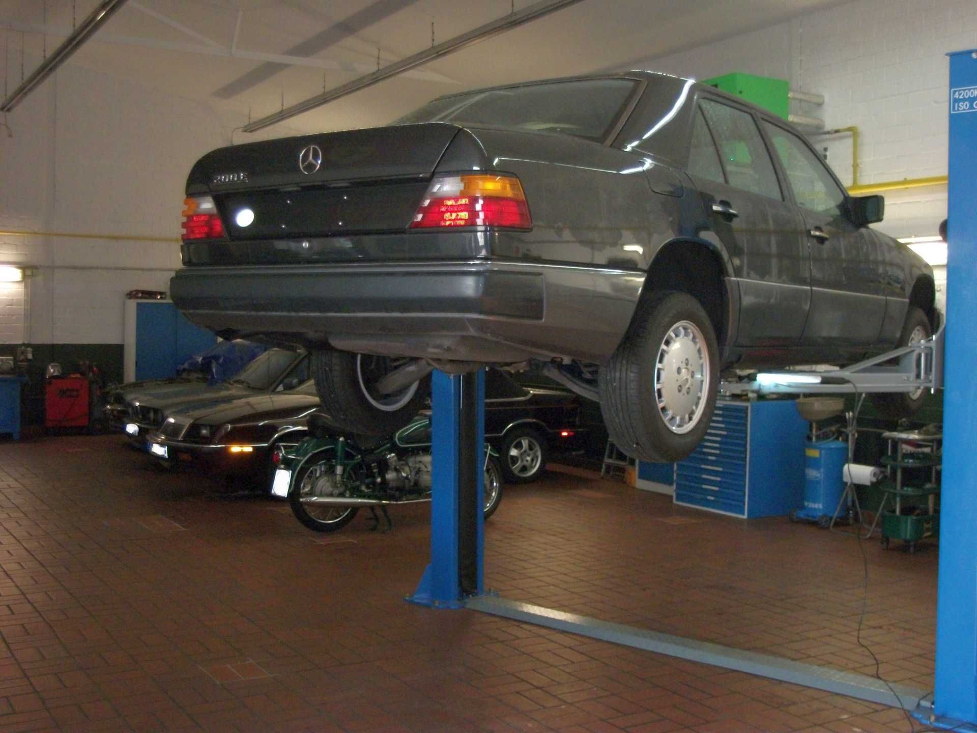 Ein Mercedes steht auf einer Hebebühne in einer Garage