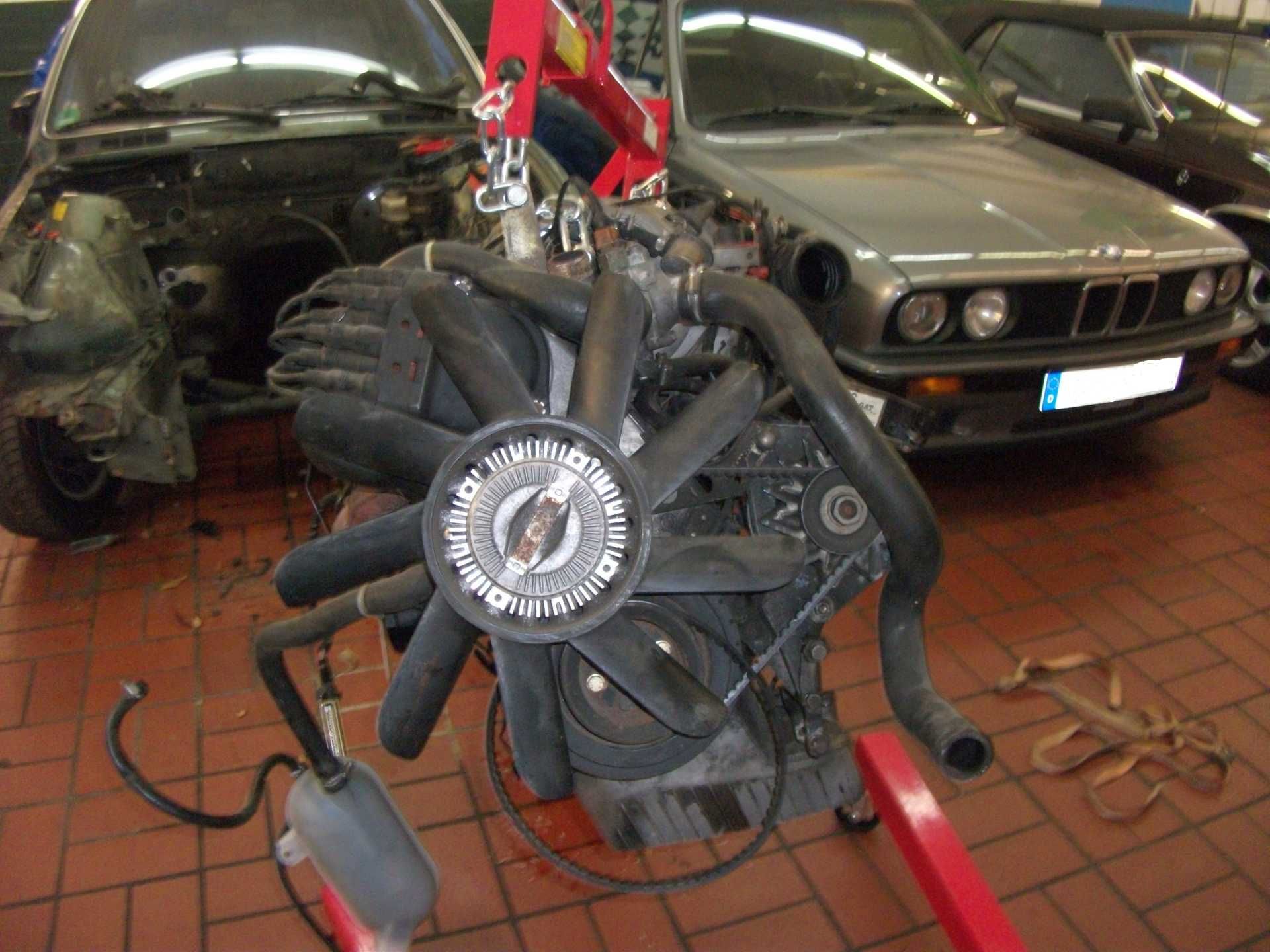 In einer Garage wird an einem BMW-Motor gearbeitet