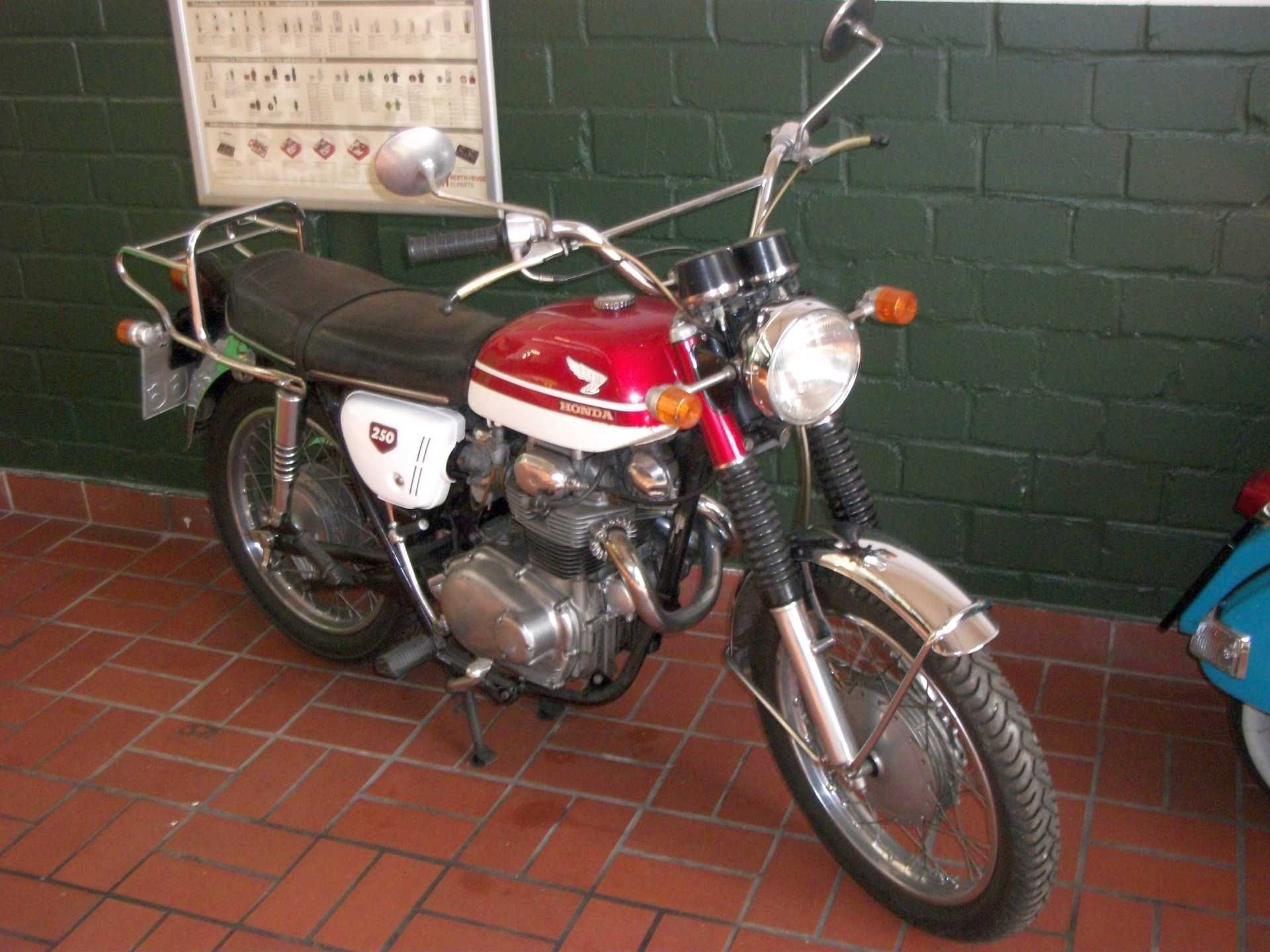 Ein rot-weißes Honda-Motorrad steht auf einem gefliesten Boden