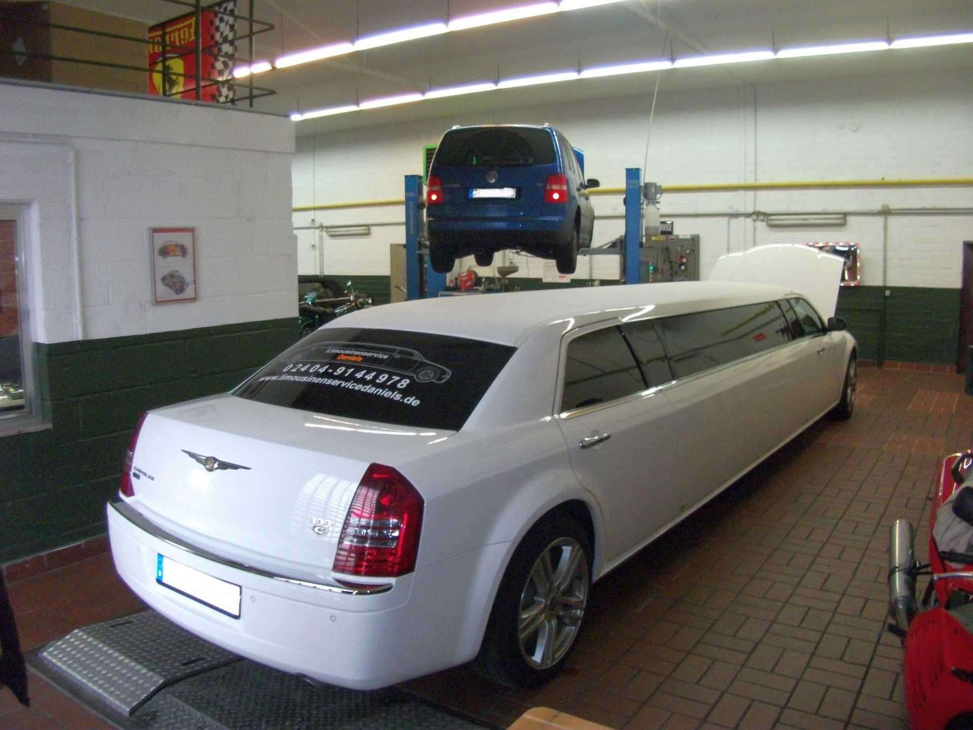Eine weiße Chrysler-Limousine steht in einer Garage