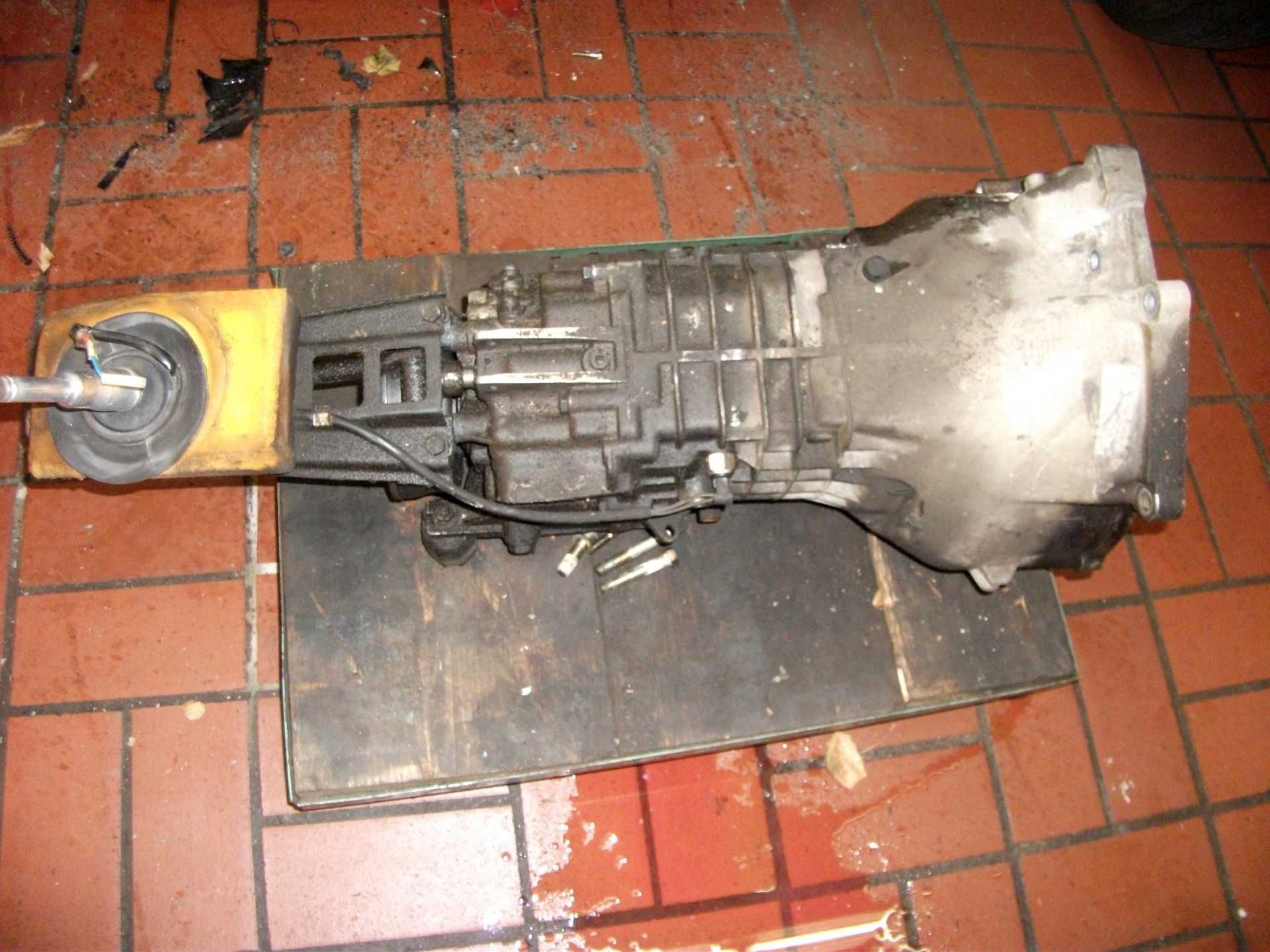 Ein Getriebe liegt auf einem Stück Holz auf einem Fliesenboden