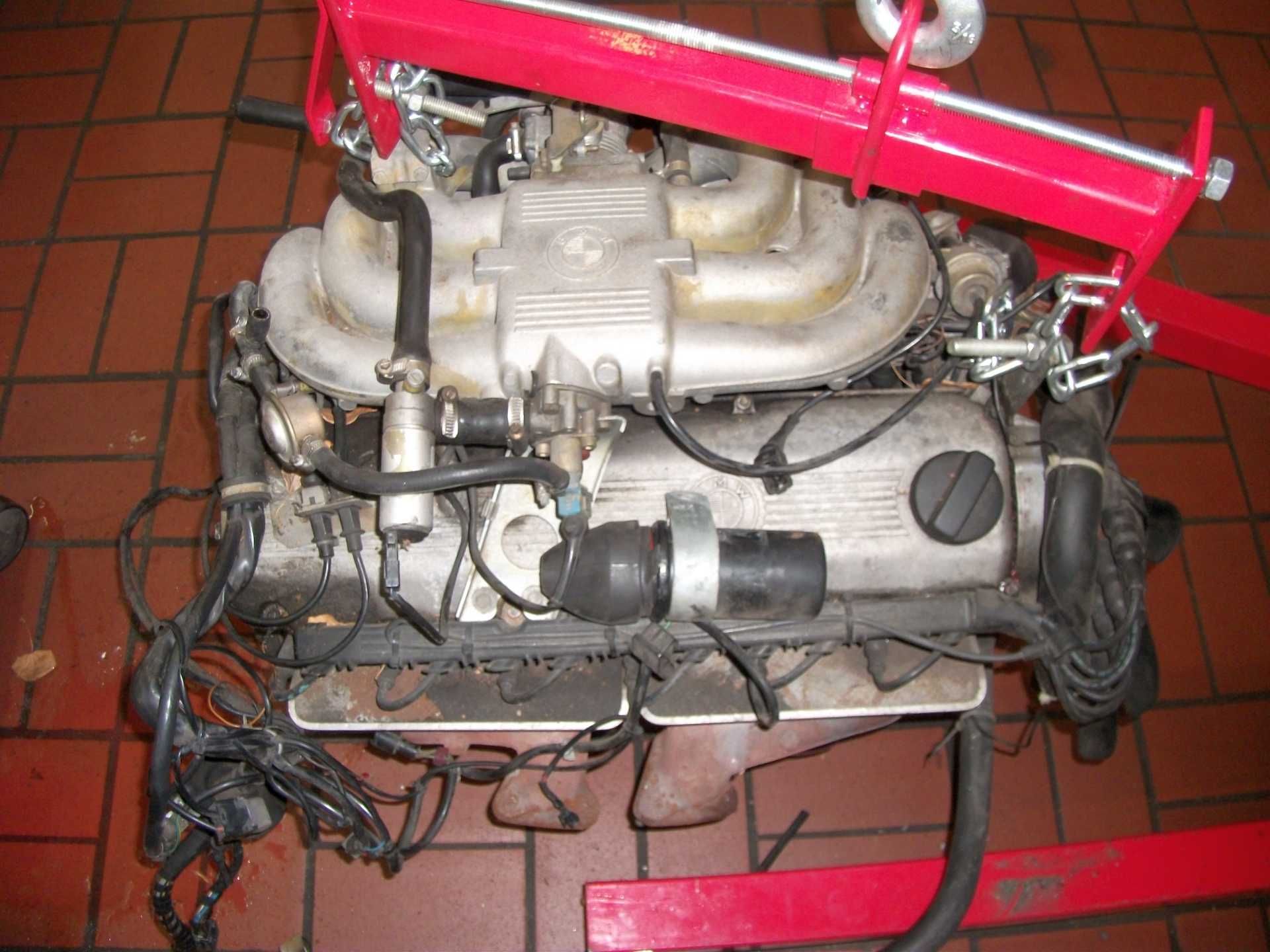 Ein BMW-Motor wird von einem roten Kran angehoben