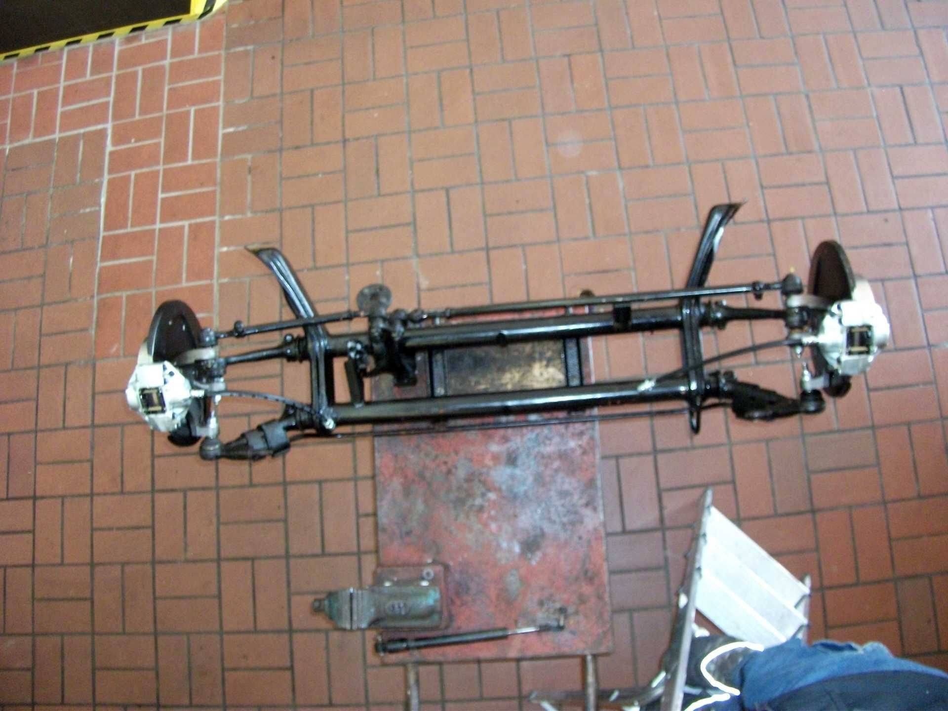 Ein Autochassis liegt auf einem Ziegelboden