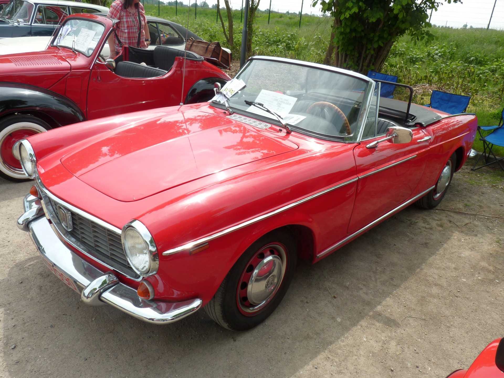 Ein rotes Cabrio steht neben einem anderen Auto