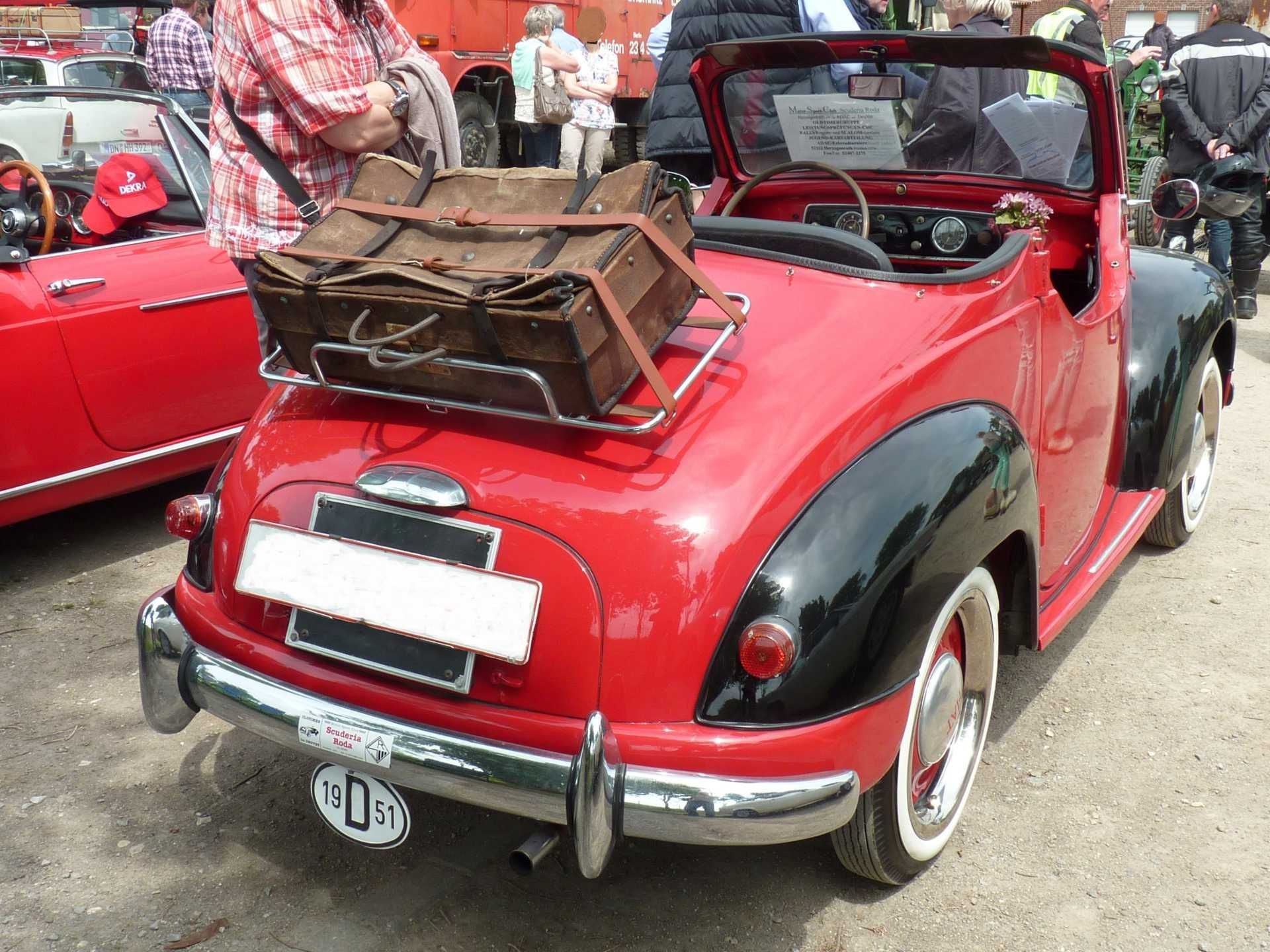 Ein rotes Auto mit einem Koffer darauf