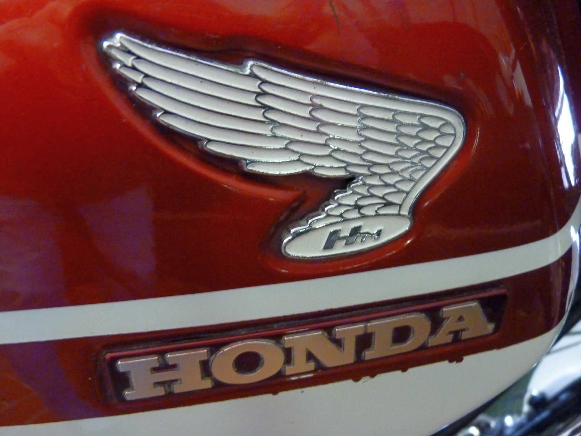 Ein rotes Honda-Motorrad mit einem silbernen Flügel an der Seite