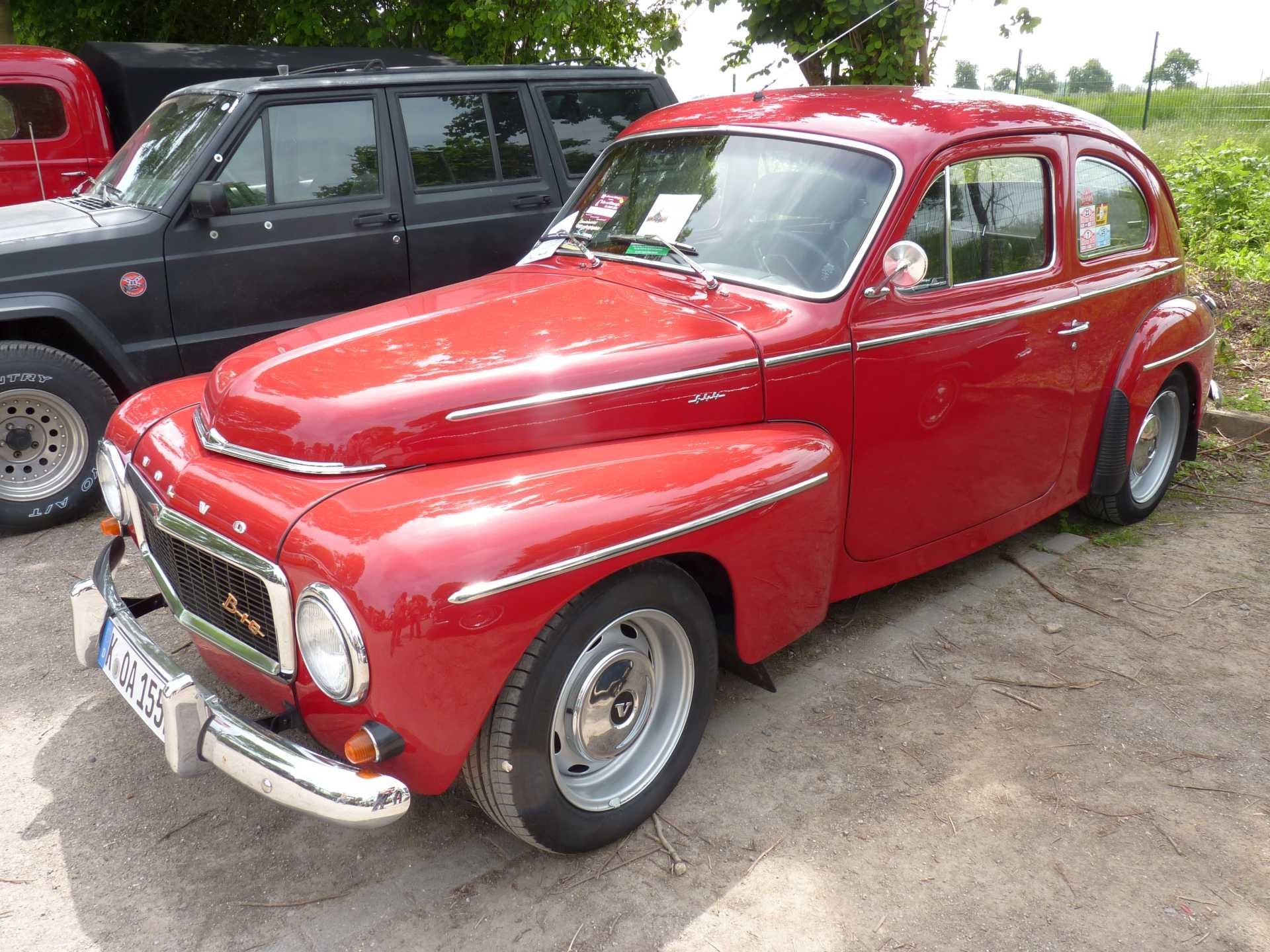 Ein rotes Auto steht neben einem schwarzen Geländewagen