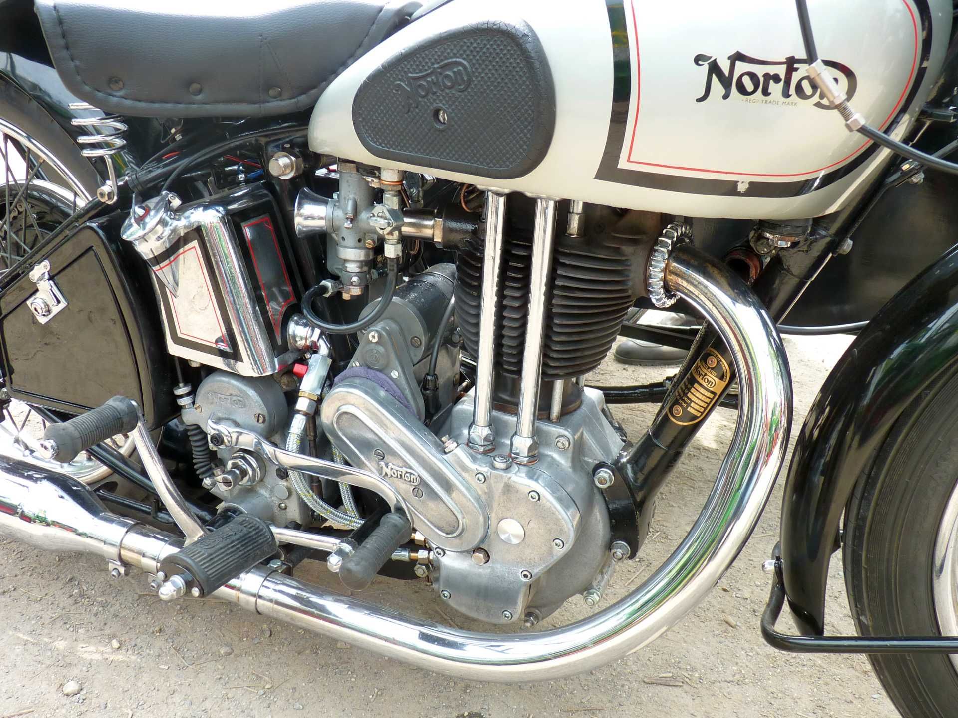 Am Straßenrand parkt ein Norton-Motorrad.