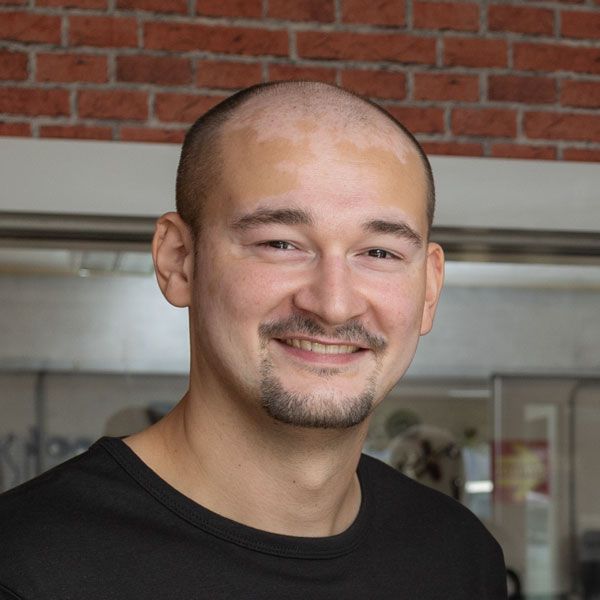 Eine Strichzeichnung des Gesichts eines Mannes mit kurzen Haaren.