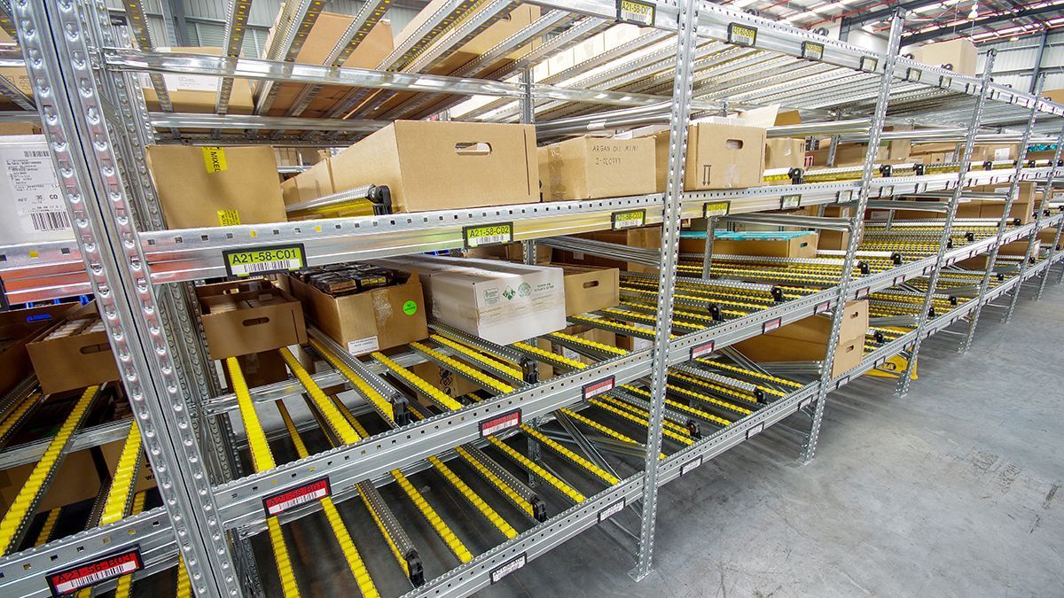 Un almacén lleno de estanterías y cintas transportadoras llenas de cajas.