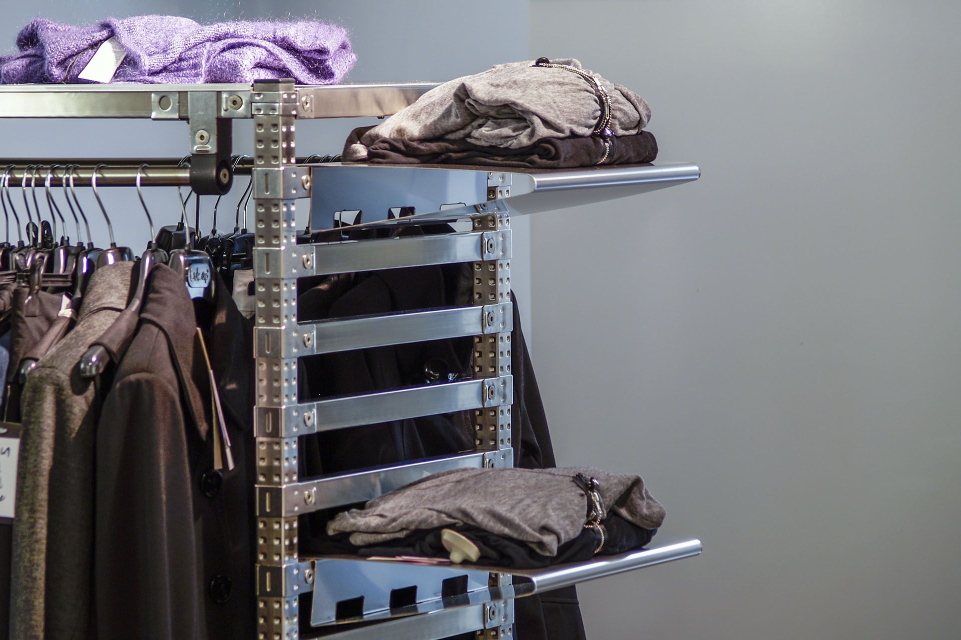 Un perchero con ropa colgada en una tienda.