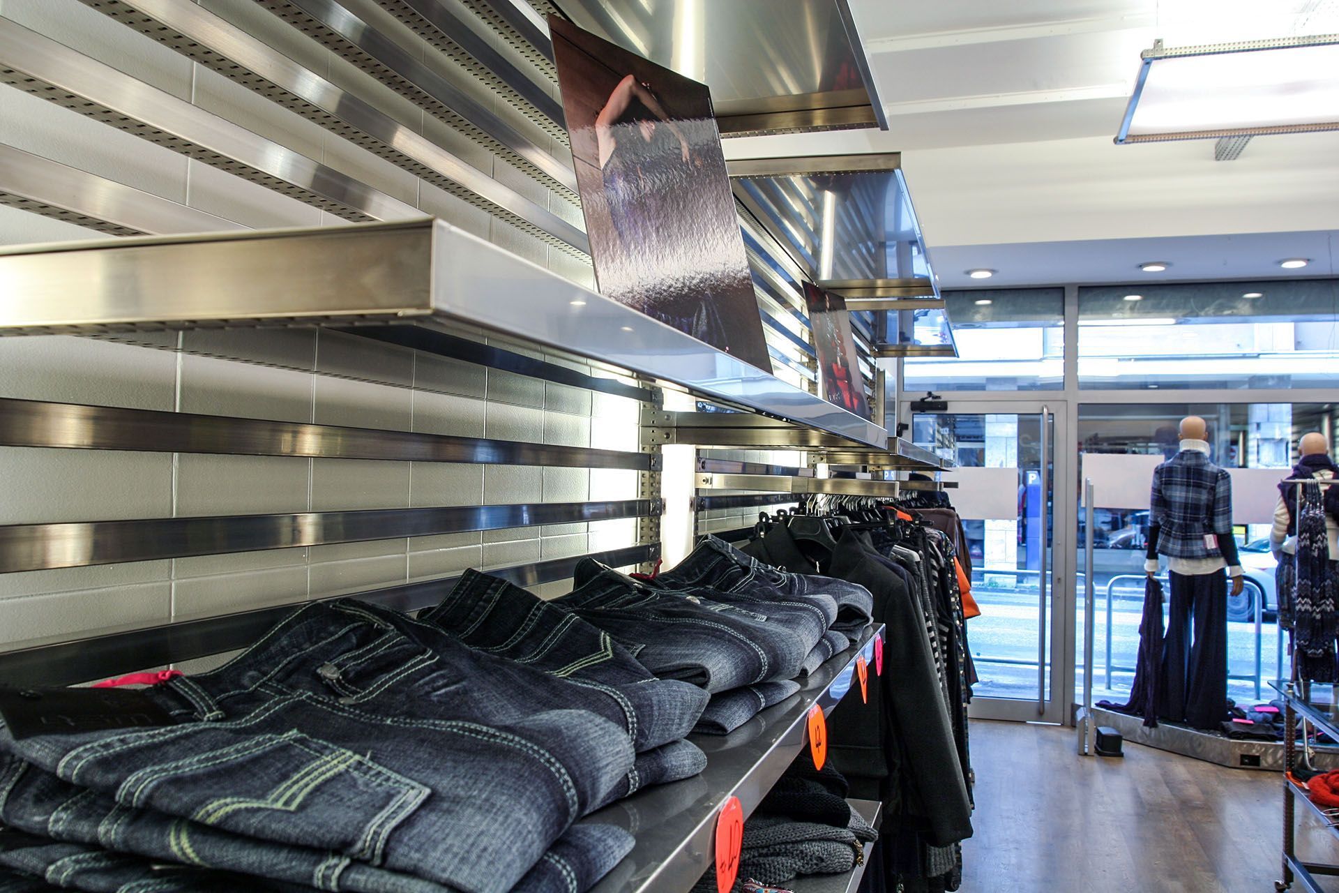 Una tienda llena de mucha ropa, incluidos jeans.