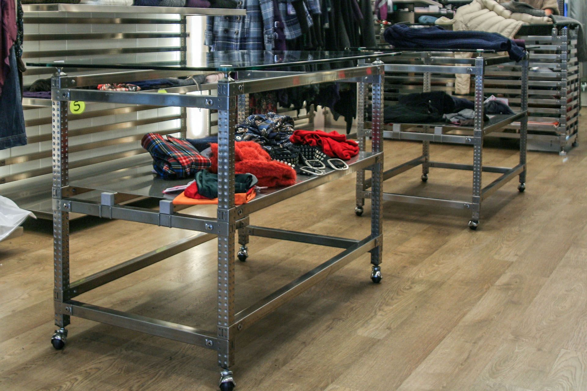 Una fila de estantes de metal con ropa en ellos en una tienda.