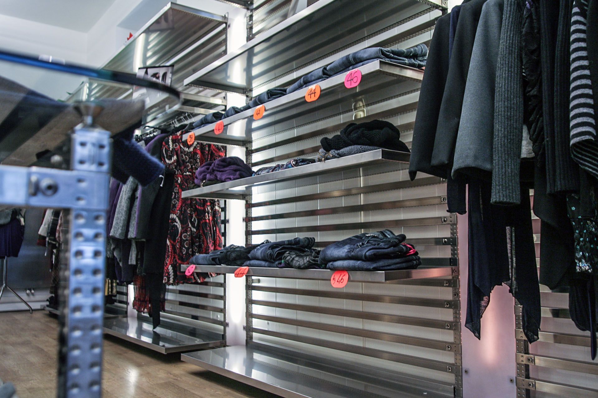 Una fila de estantes con ropa en una tienda.