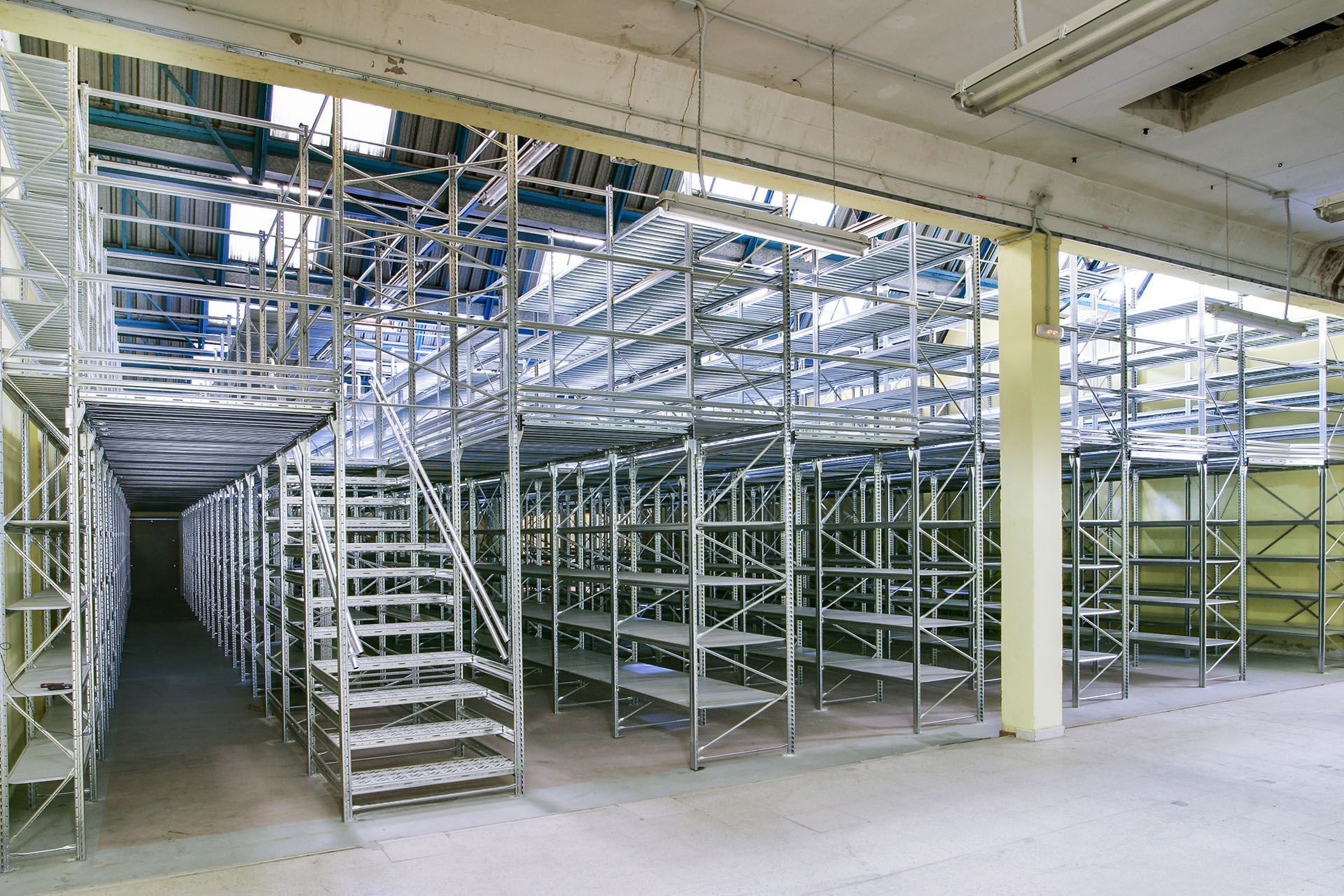 Un almacén vacío con muchos estantes y escaleras.