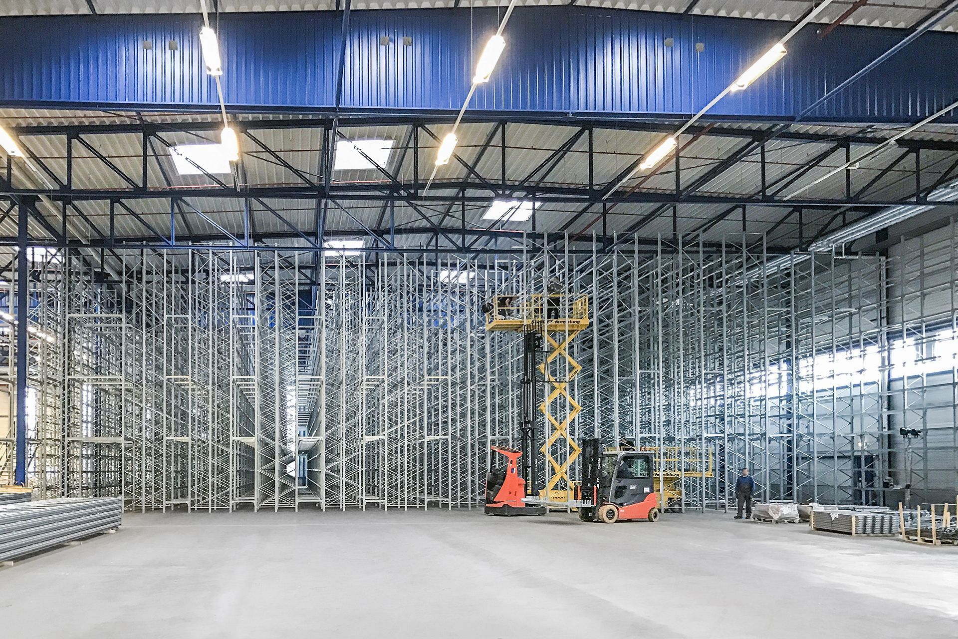 Un gran almacén con una carretilla elevadora en el medio.
