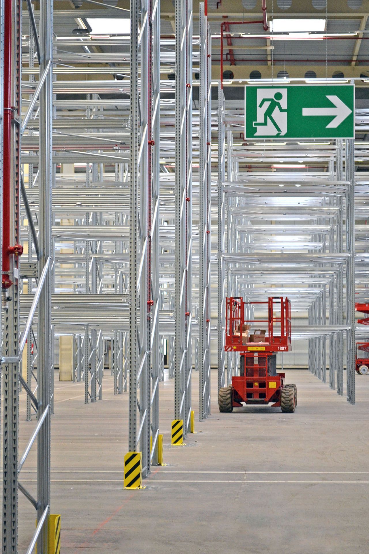 Un almacén con una señal de salida verde y una flecha que apunta hacia la derecha.