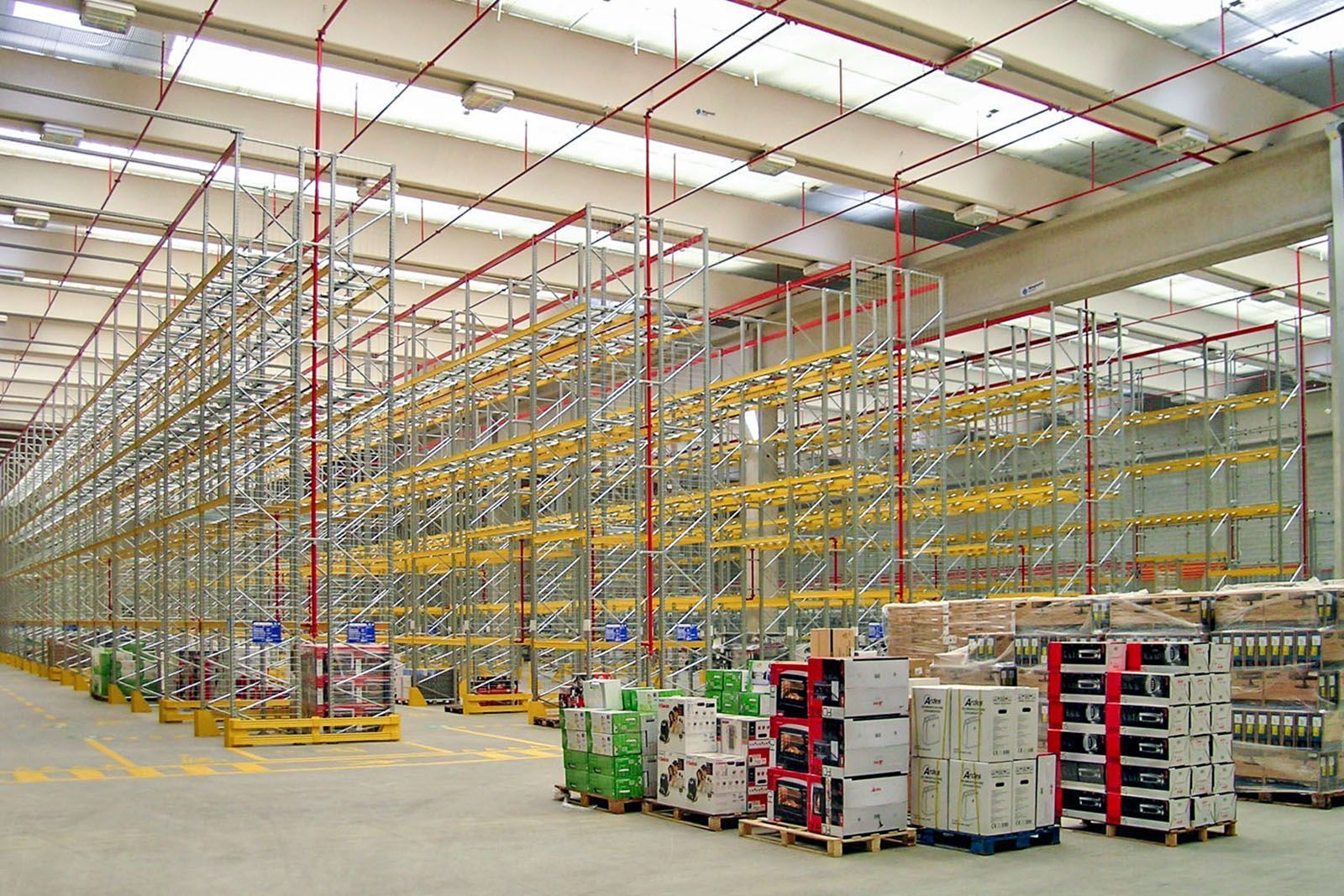 Un gran almacén lleno de estanterías y paletas.