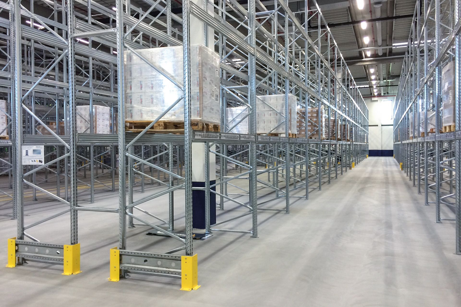 Un gran almacén lleno de estanterías y paletas.