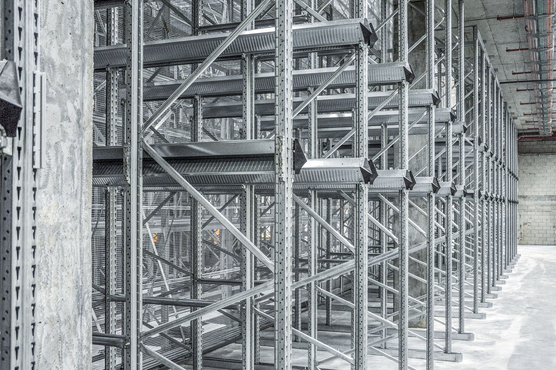 Una fotografía en blanco y negro de un almacén con estantes de metal.