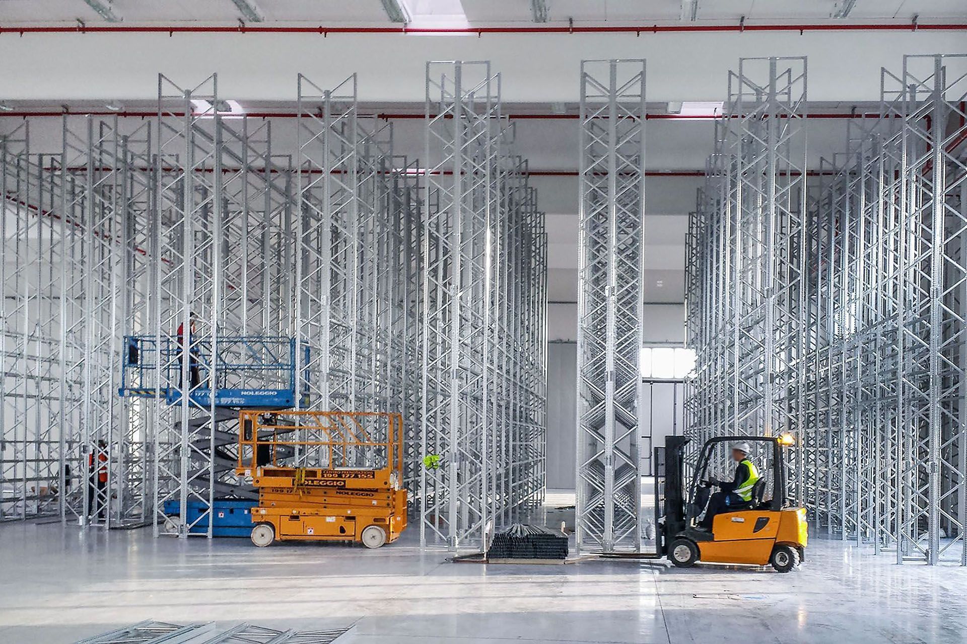 Un hombre conduce una carretilla elevadora en un gran almacén.