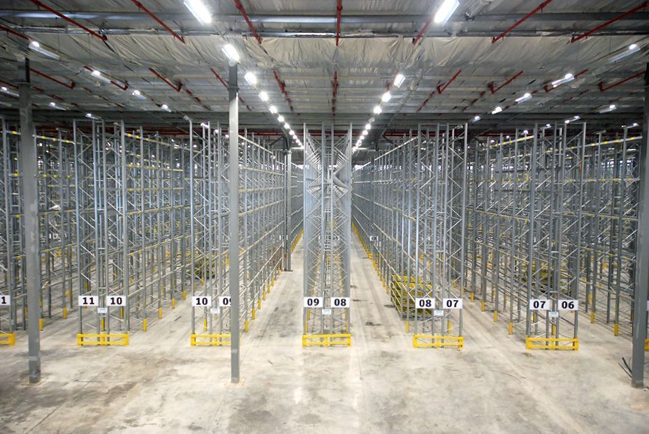 Un gran almacén lleno de estanterías y paletas.