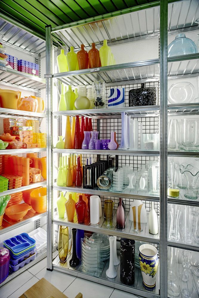 Una habitación llena de estantes llenos de jarrones y velas.