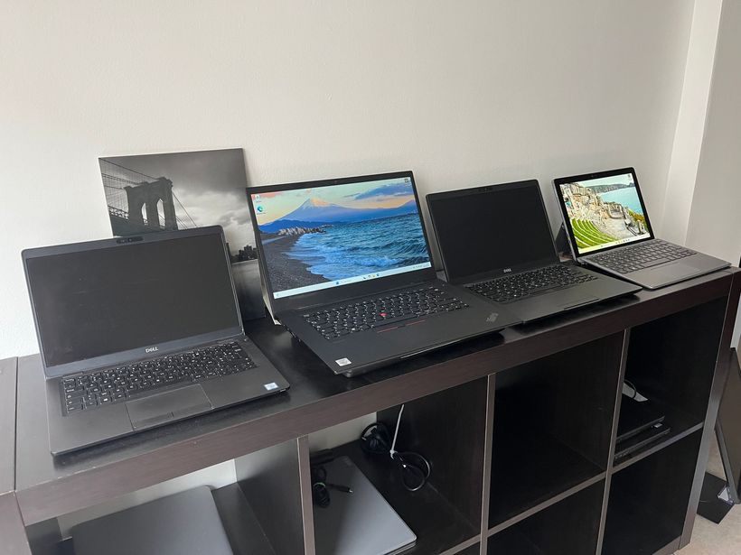 Un homme de dos devant 3 ordinateurs