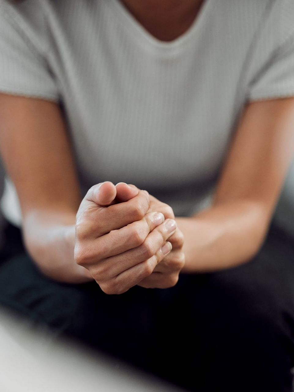 Une femme assise les coudes sur les genoux