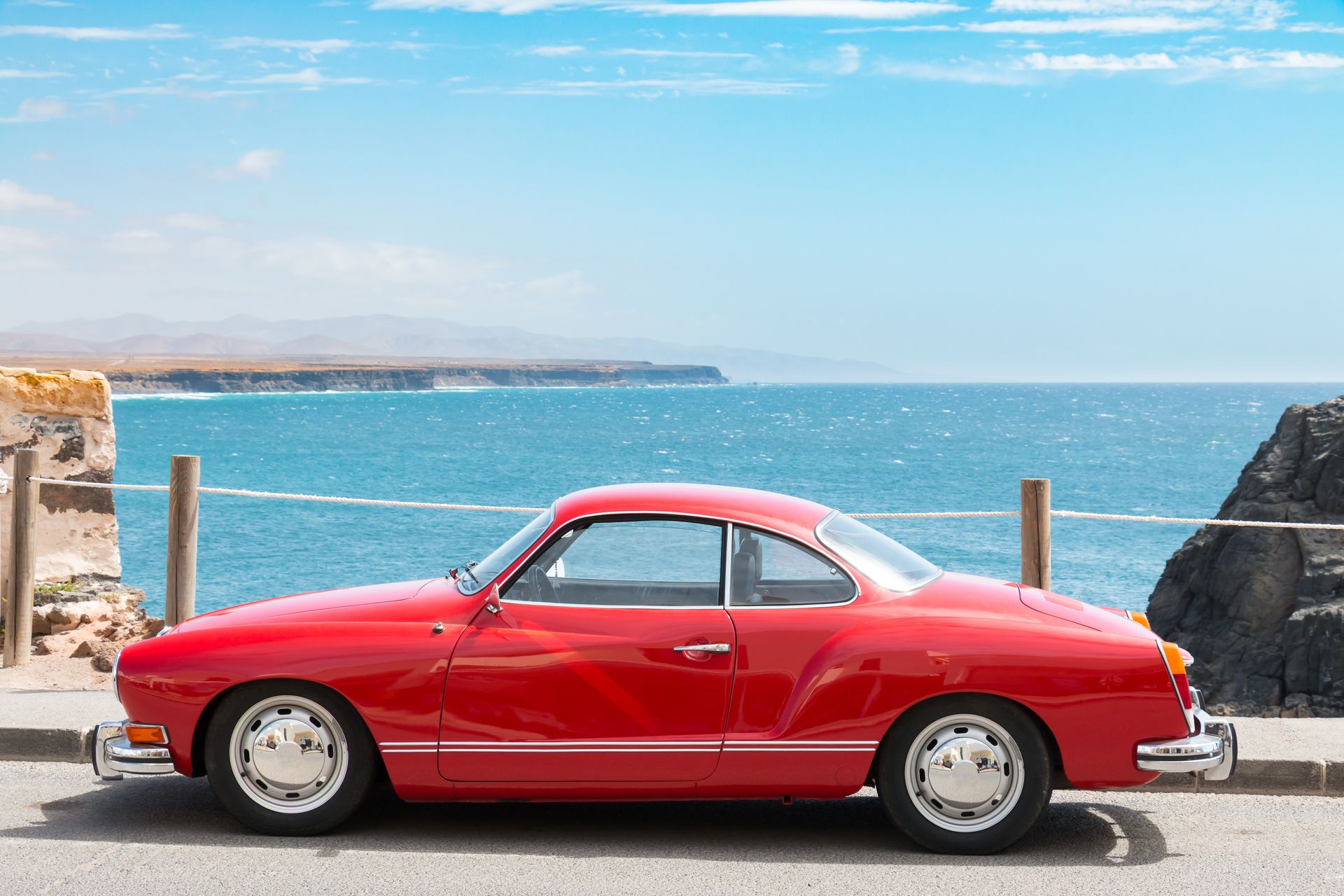 Voiture ancienne rouge devant l'Océan