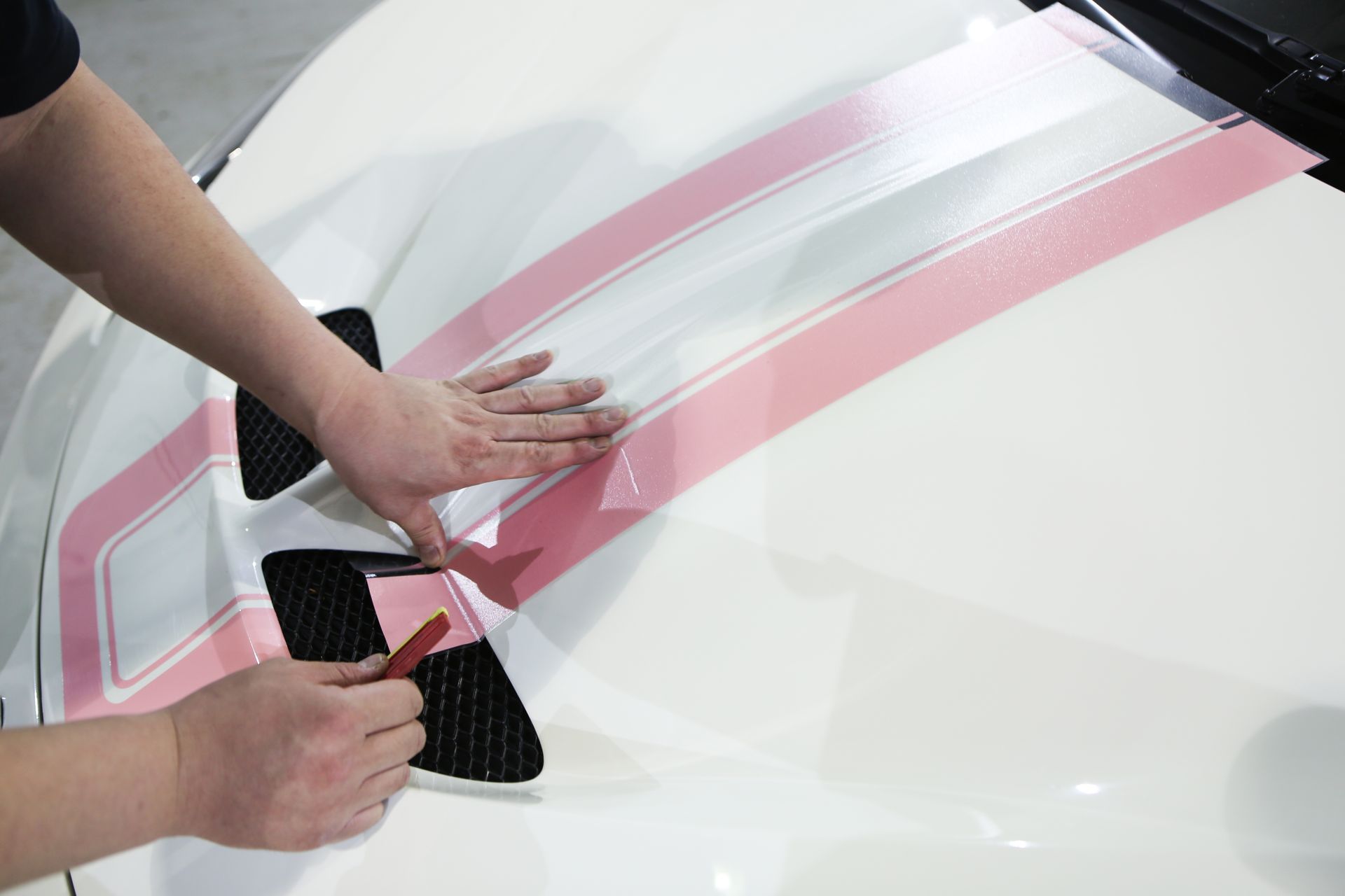 Application d'autocollants roses sur une voiture