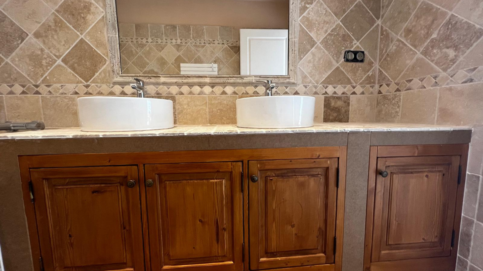 Une salle de bain avec deux lavabos et un miroir.