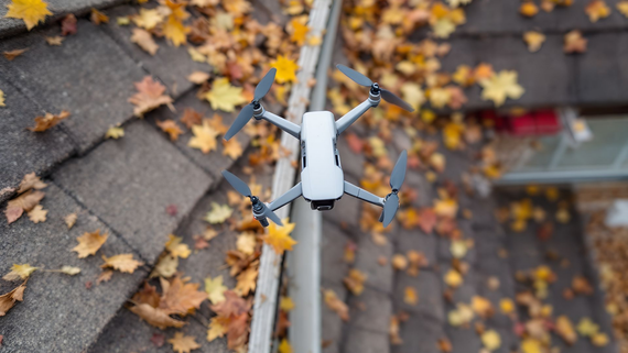 Une gouttière obstruée par des feuilles mortes, avec un drone en survol