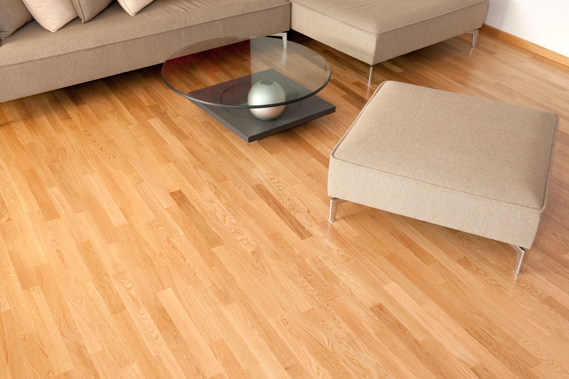 Parquet en bois clair avec meubles beiges dans un salon moderne.