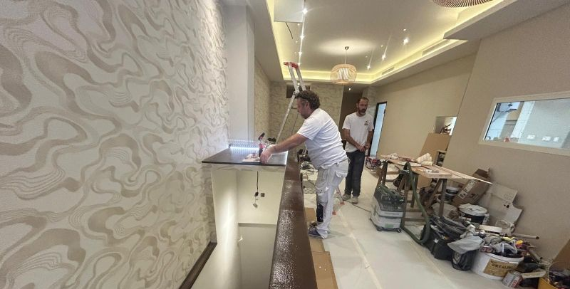 Des messieurs posent le revêtement mural dans une pièce