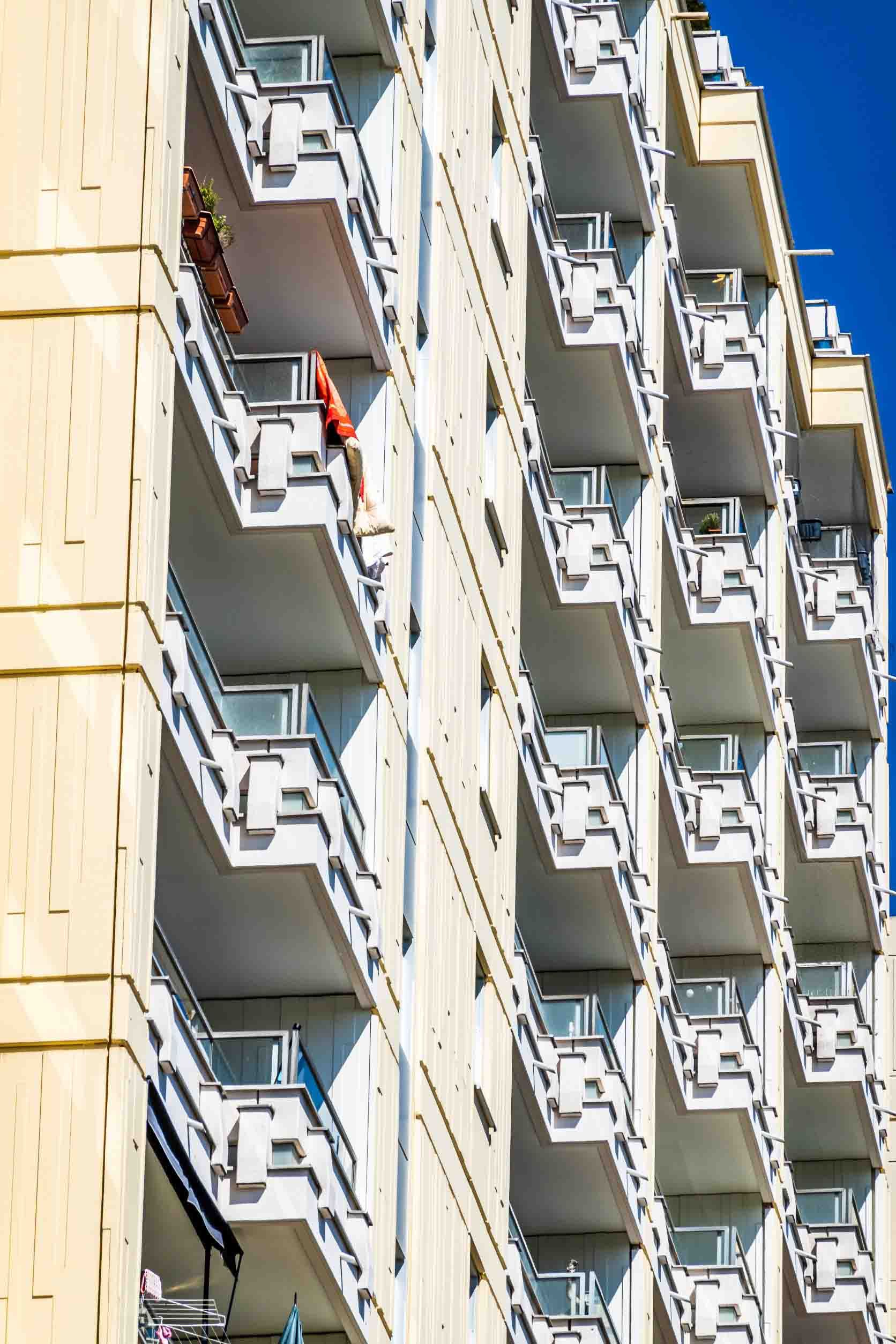 Un edificio con muchos balcones y un cielo azul al fondo.