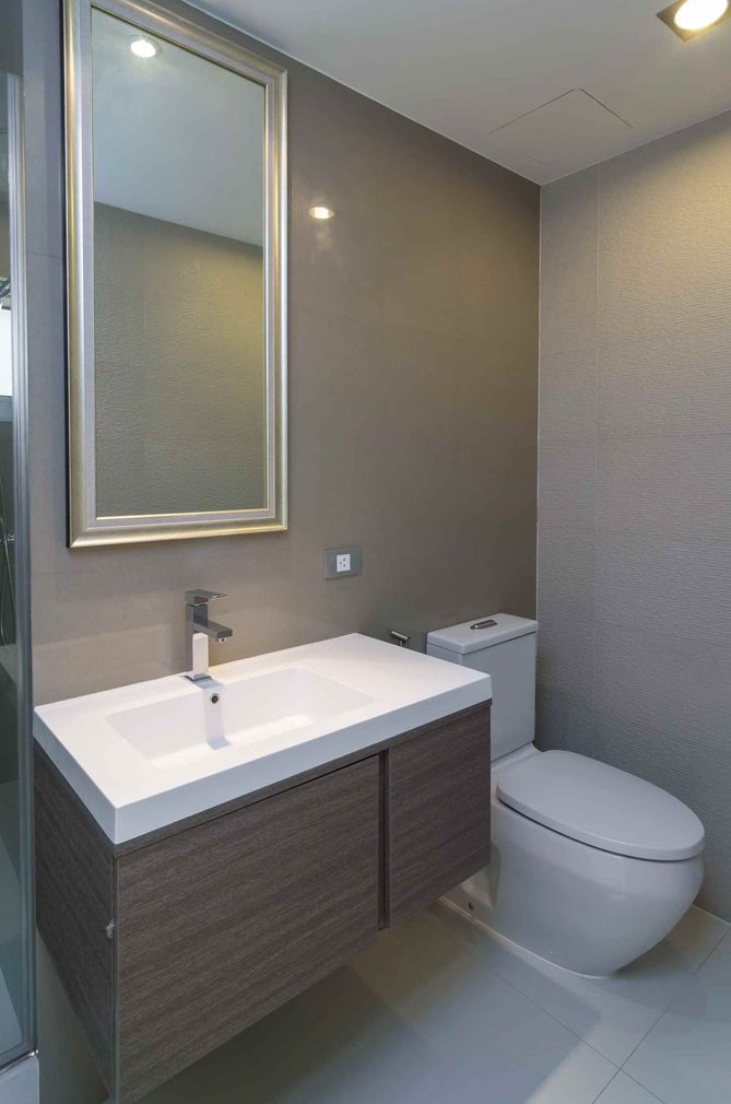 Un baño con lavabo, inodoro y espejo.