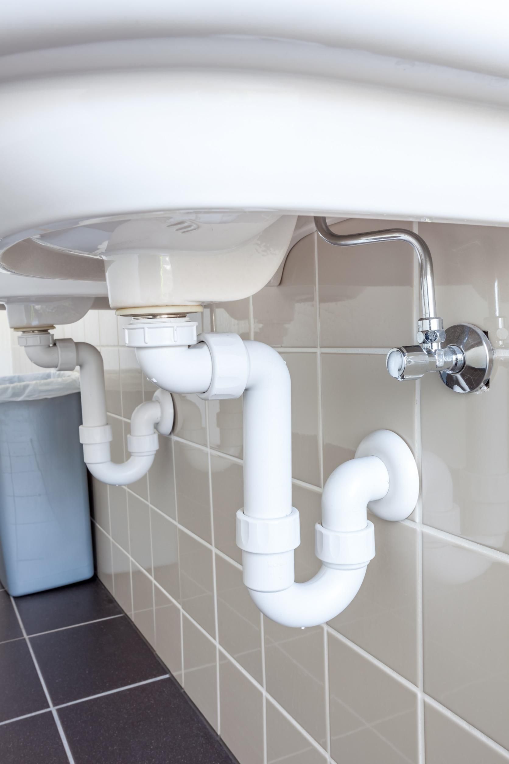 Un lavabo de baño con dos tubos blancos debajo.
