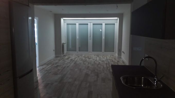 Una habitación vacía con un fregadero y un refrigerador
