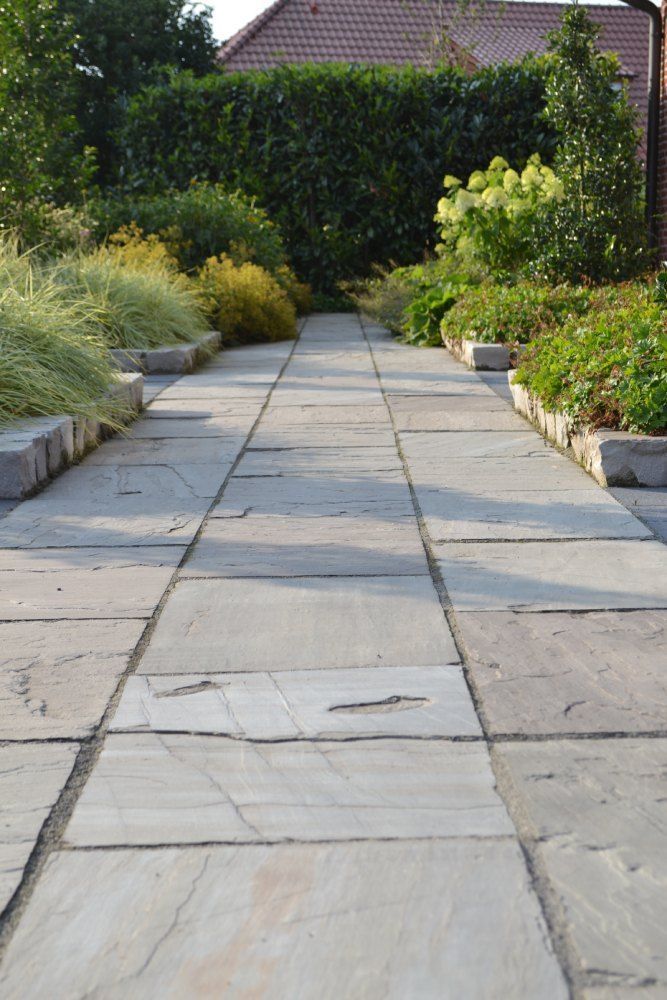Ein Steinweg, der zu einem Haus in einem Garten führt