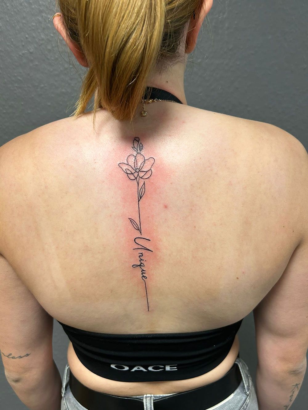 Eine Frau hat eine Blumentätowierung auf ihrem Rücken.