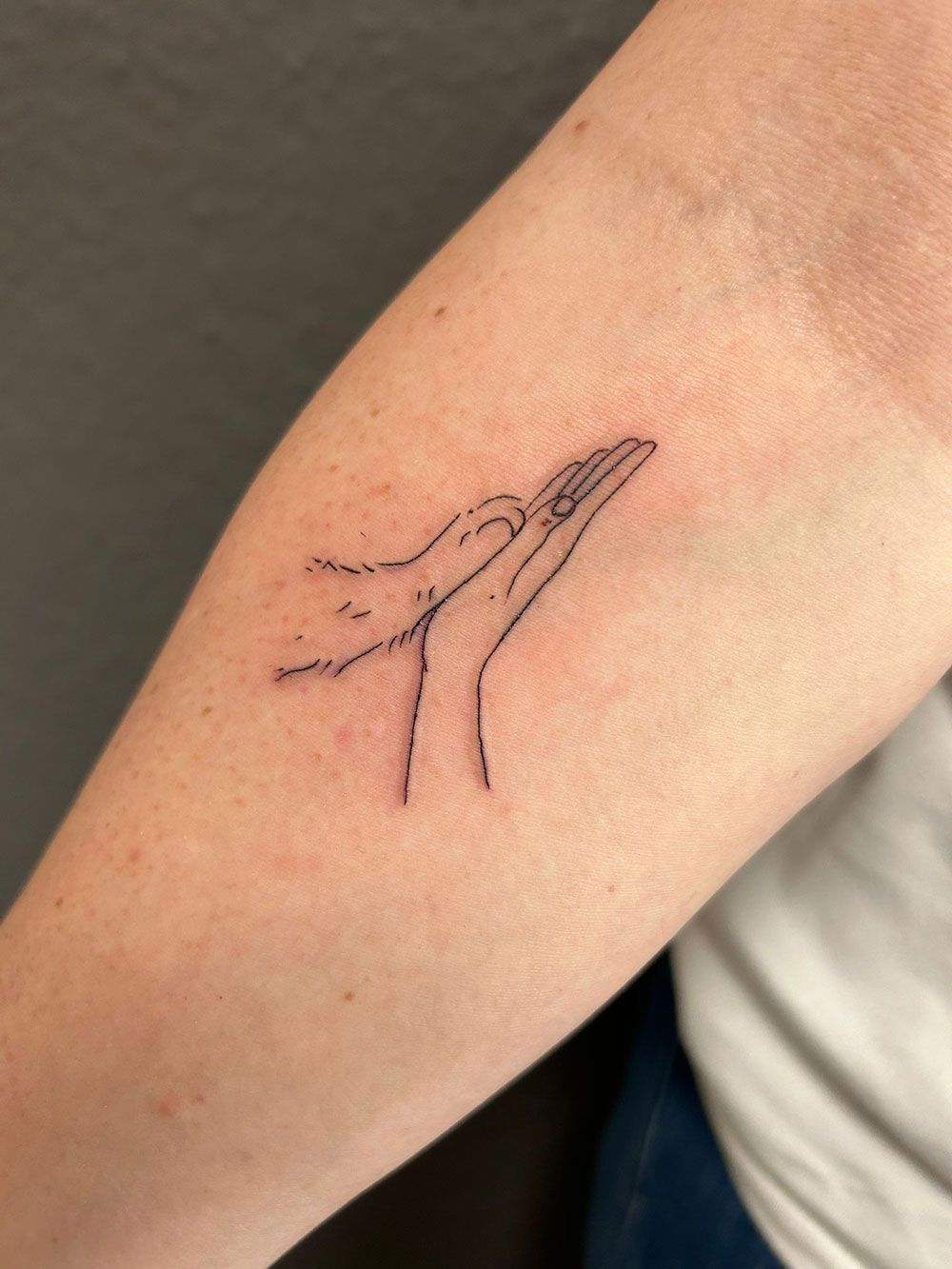 Ein kleines Tattoo eines Wals auf dem Arm einer Person