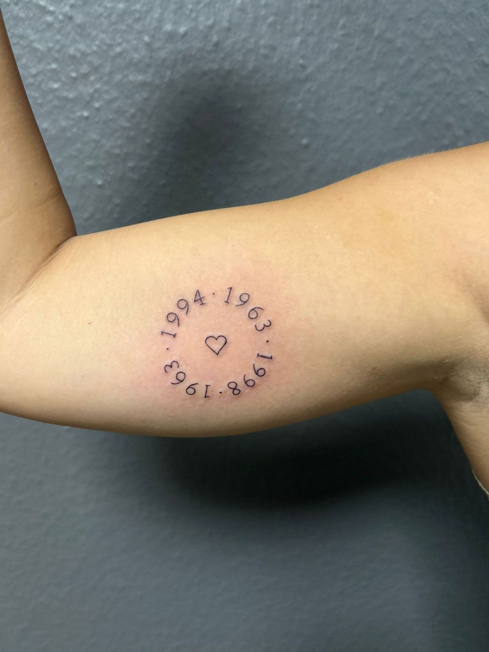 Eine Person hat ein Tattoo auf dem Arm mit der Aufschrift 1994