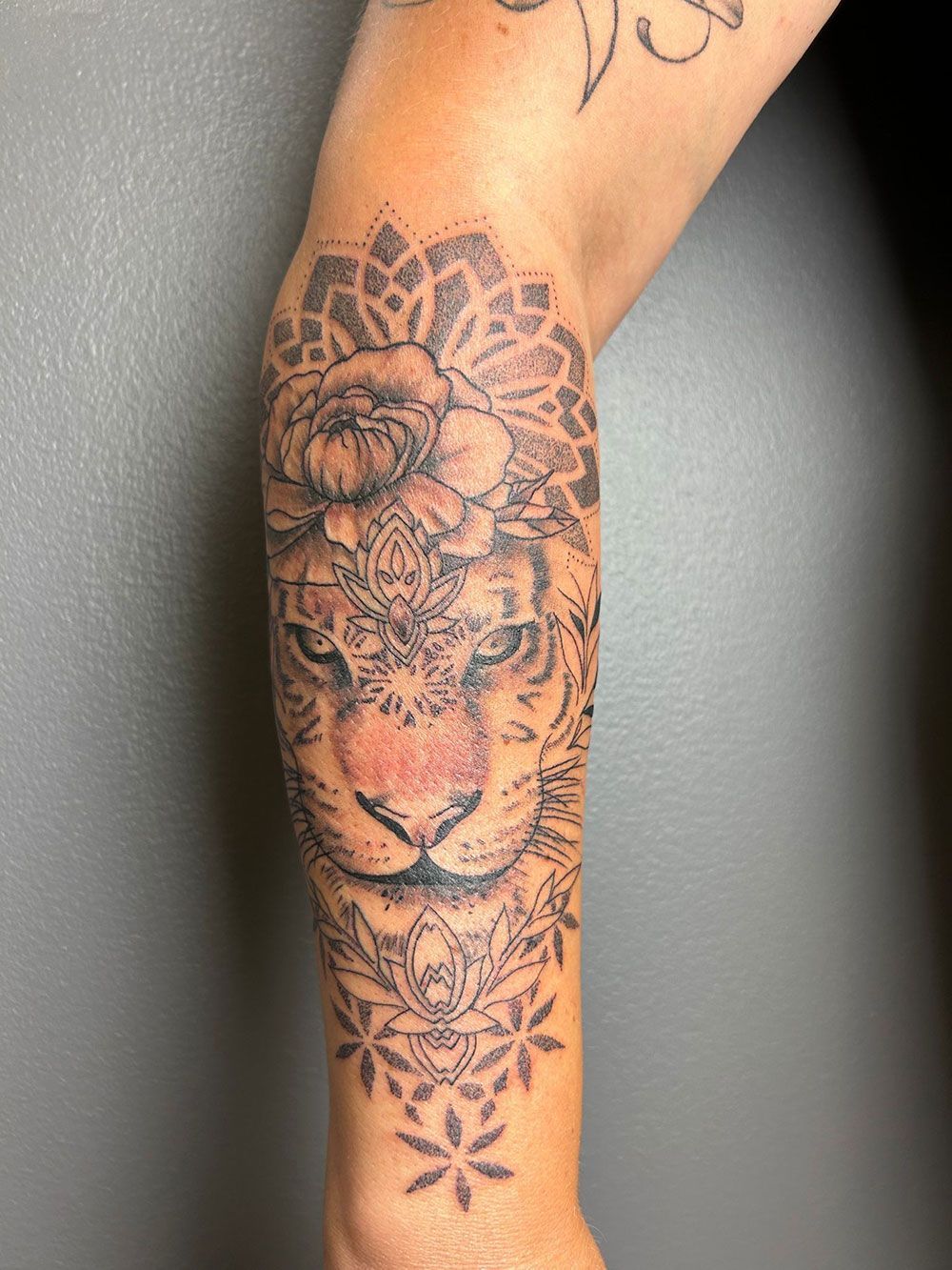 Eine Frau hat eine Tigertätowierung auf ihrem Bein.