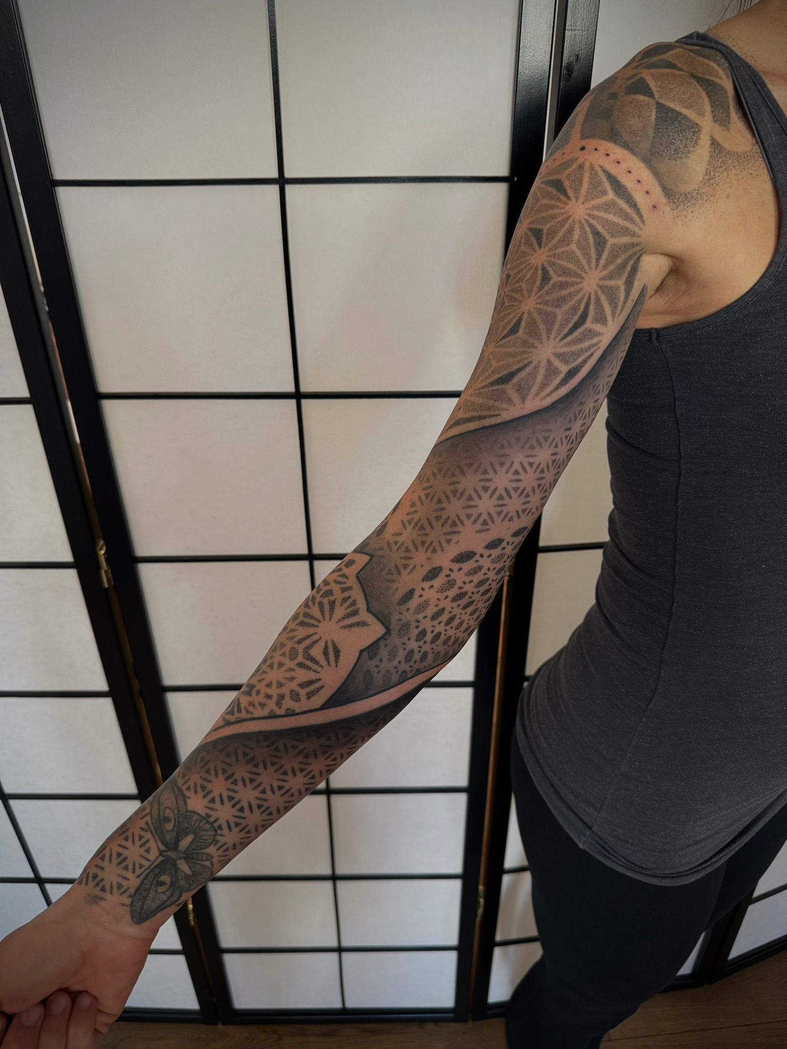 Eine Frau hat eine Tätowierung auf ihrem Arm und ihrer Schulter.