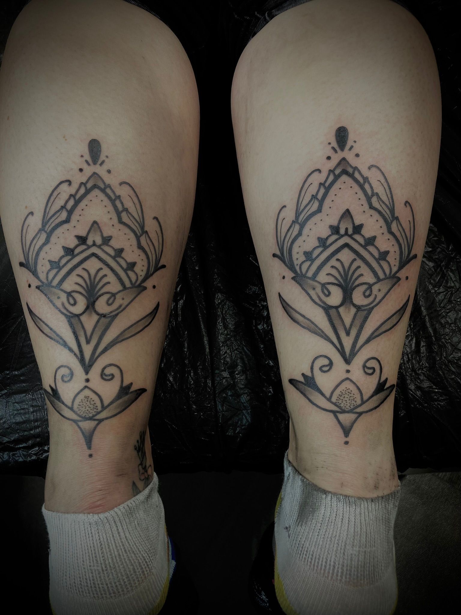 Ein Paar Beine mit einem schwarz-weißen Tattoo darauf