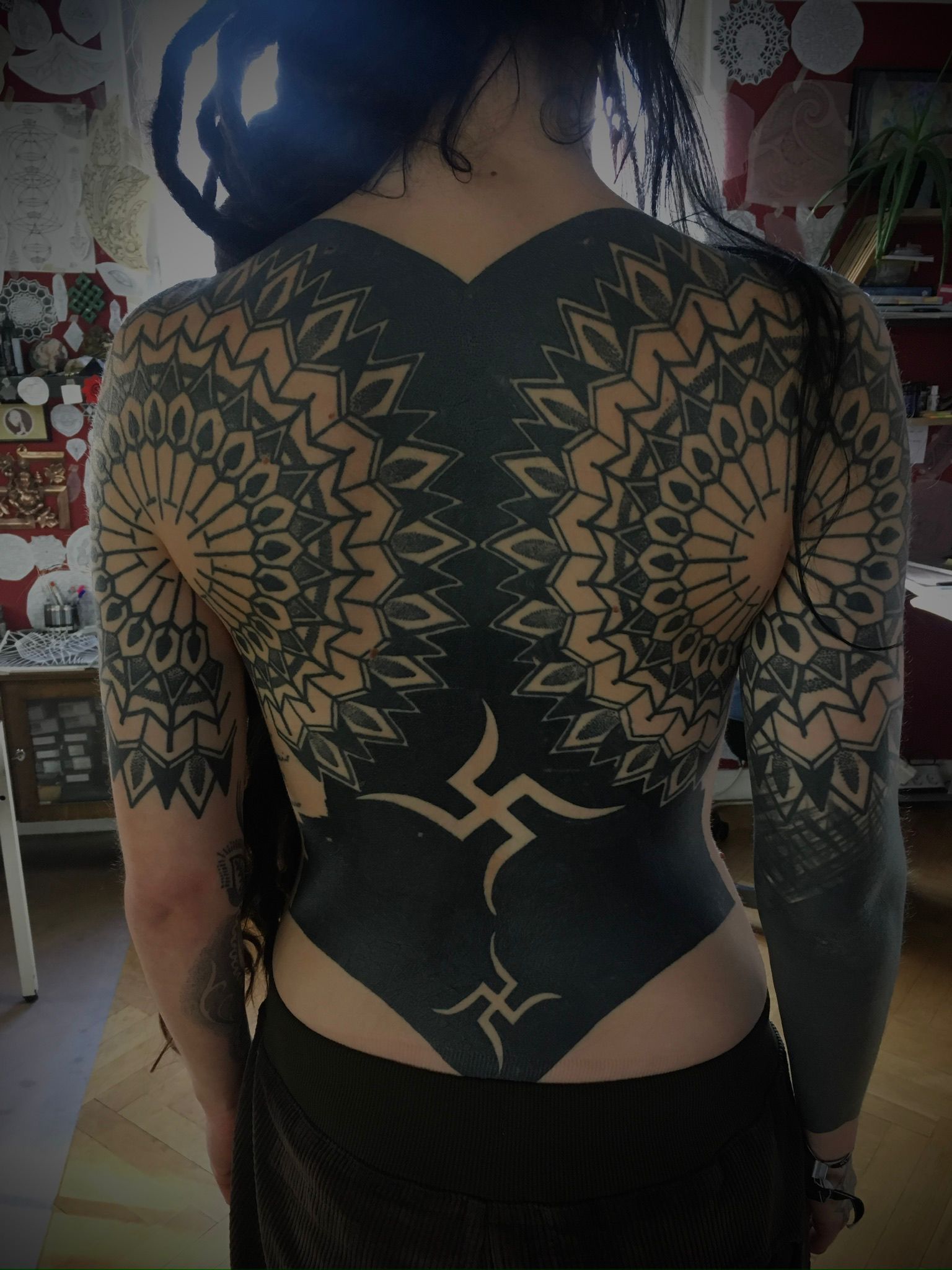 Eine Frau mit vielen Tattoos auf dem Rücken und den Armen